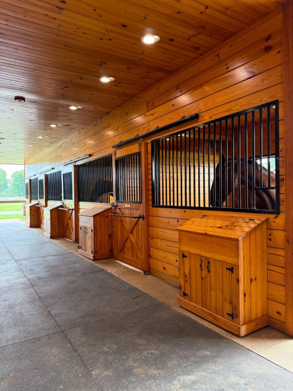 The barn aisle, with stall fronts, name plates and a personal box outside each door